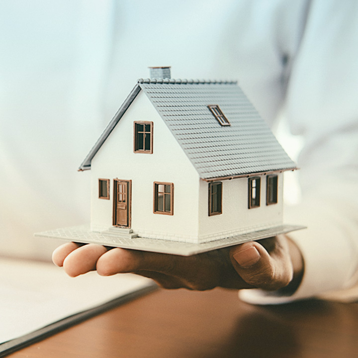 Photo of person holding model house in the palm of their hand Photo of person holding model house in the palm of their hand