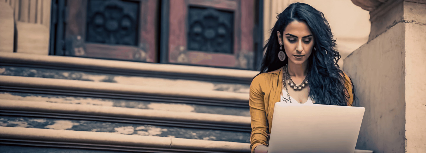 Women sitting on stairs using laptop