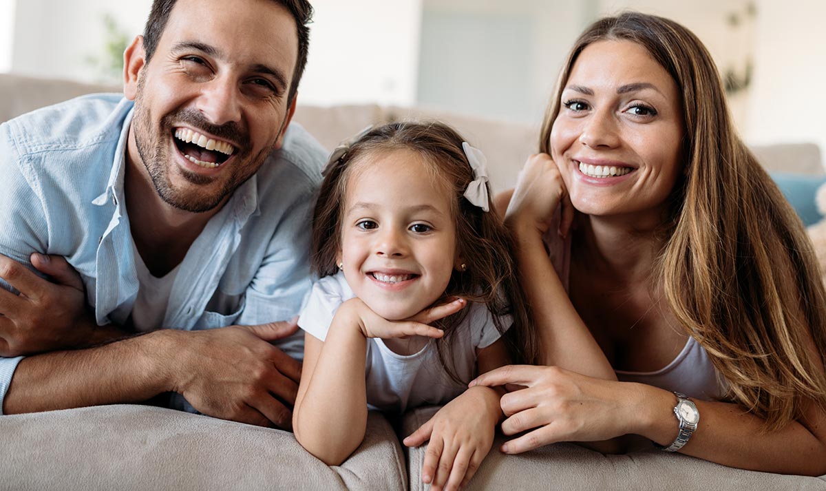 Family in their home smiling..  NSPIRE Answers: Read about what NSPIRE is, why it’s happening, what it will accomplish, and more!