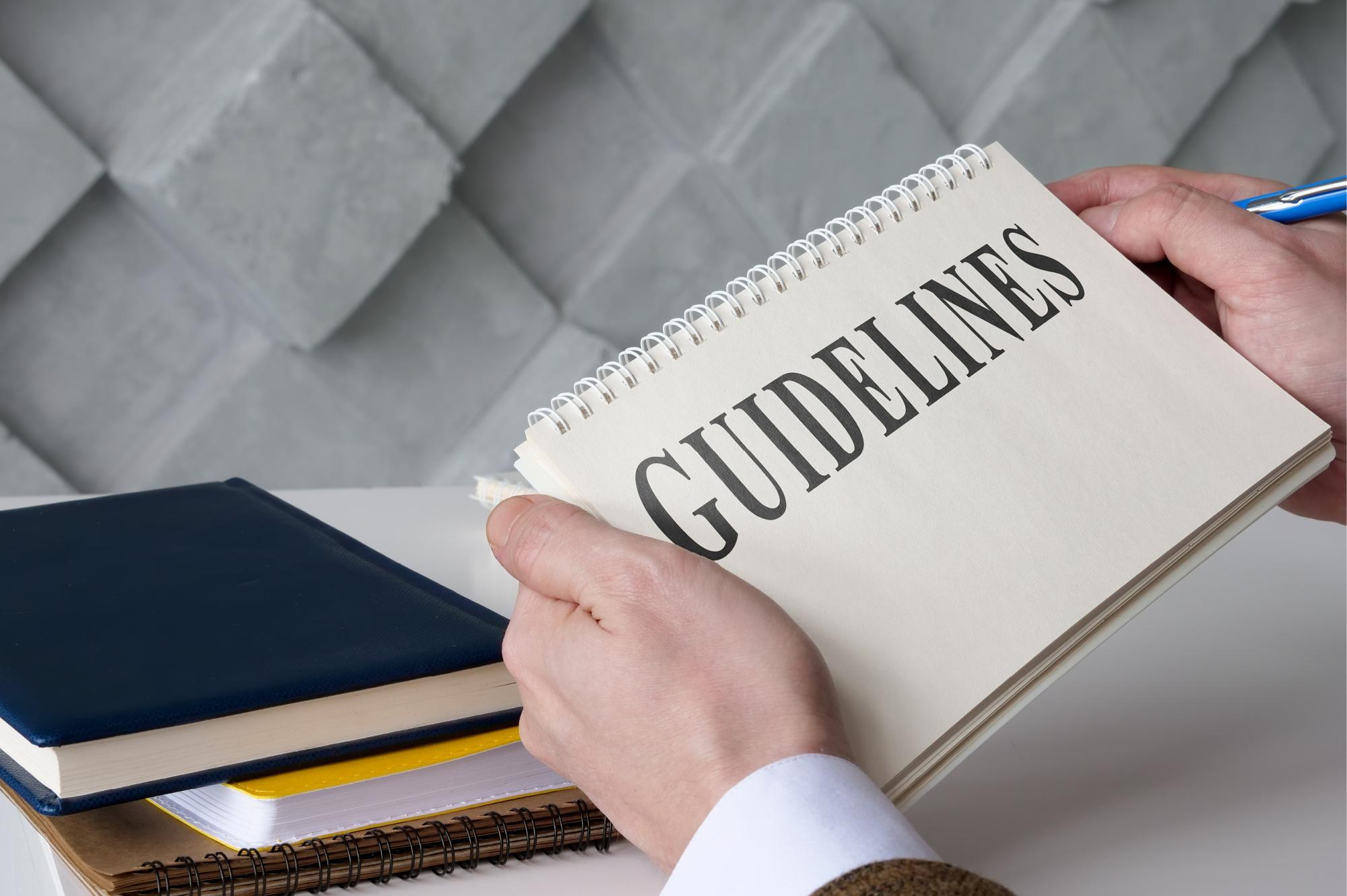 A picture of a man holding a book showing guidelines