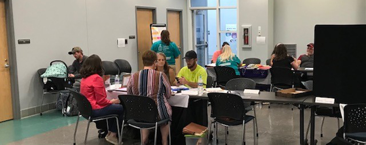[Kentucky Legal Aid and Catholic Charities serve survivors at their tables during the Hopkins County Disaster Recovery Resource Fair event]. 